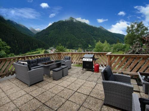 a patio with chairs and a grill and mountains at Holiday home near St Anton am Arlberg with sauna in Sankt Anton am Arlberg