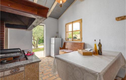 a kitchen with a table and a refrigerator at Stunning Home In Labin With Outdoor Swimming Pool in Labin