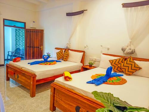 ein Schlafzimmer mit 2 Betten und Spielzeug darauf in der Unterkunft Sigiri Tarushan Home Stay in Sigiriya