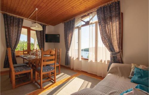 Una sala de estar con mesa y sillas y ventanas. en Stunning Home In Grscica With Kitchen, en Prizba
