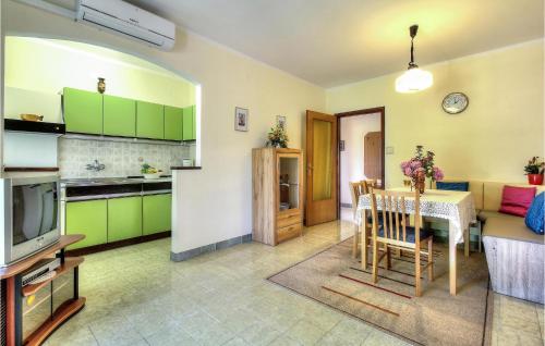 a kitchen and living room with a table and a television at Apartment Mugeba I in Poreč