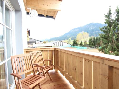 2 sedie sedute su un balcone con vista di Modern apartment near the ski area a Brixen im Thale