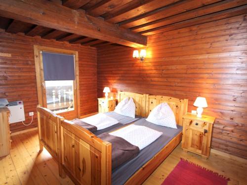 a bedroom with two beds in a log cabin at Modern holiday apartment in a renovated farmhouse in Fresach Carinthia in Fresach