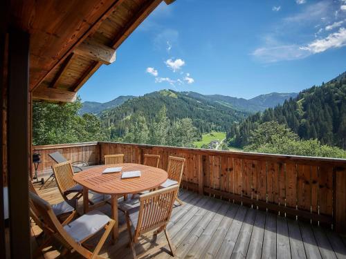 a wooden deck with a table and chairs on it at Modern chalet in Saalbach Hinterglemm with sauna in Saalbach-Hinterglemm