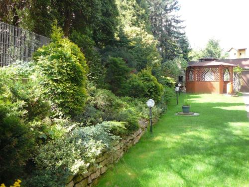 a garden with a stone wall and a gazebo at Ośrodek Wypoczynkowy Zapalenica in Szczyrk