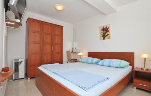 um quarto com uma cama grande e almofadas azuis em Awesome Apartment In Okrug Gornji With House Sea View em Trogir
