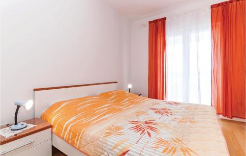 a bedroom with a bed and a window with orange curtains at Awesome Apartment In Turanj With Kitchen in Turanj