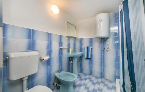 a blue tiled bathroom with a toilet and a sink at Beautiful Home In Zagorje With 1 Bedrooms And Wifi in Zagorje