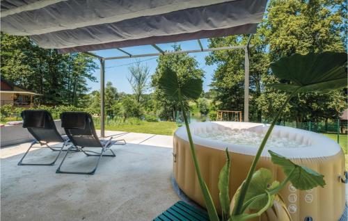 - un bain à remous sur une terrasse avec 2 chaises dans l'établissement Two-Bedroom Holiday Home In Pokupska Slatina, à Pokupsko