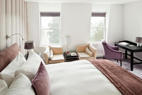 a bedroom with a bed and a desk with a piano at Camden Harbour Inn a member of Small Luxury Hotels in Camden