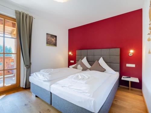 a bedroom with a large bed with a red wall at Apartment with a lift in Mittersill Salzburg in Hollersbach im Pinzgau