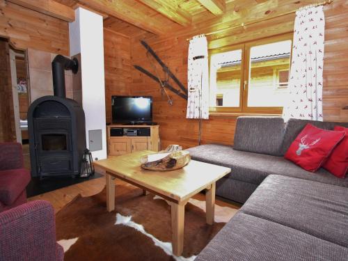 a living room with a couch and a stove at Comfortable Chalet with Whirlpool and Sauna in Krimml in Krimml