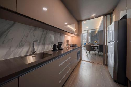 a kitchen with a sink and a refrigerator at Wyndham Bangkok Queen Convention Centre in Bangkok