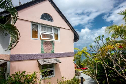 a pink house with a window and trees at Villa Caribbean Dream in Vieux Fort
