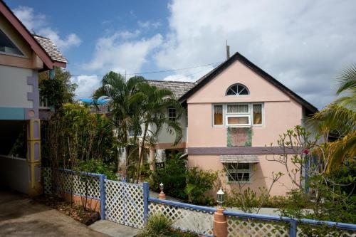 a pink house with a blue fence at Villa Caribbean Dream in Vieux Fort
