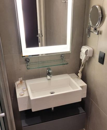 a bathroom with a white sink and a mirror at Alphaville Stay Residences in Barueri