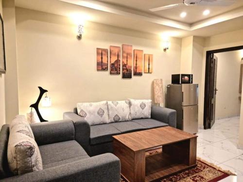 a living room with a couch and a refrigerator at Tranquil & Delightful 1 Bed Apt In Bahria Town in Rawalpindi