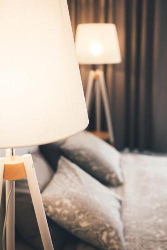 a bedroom with a lamp and pillows on a bed at Ring Stop Holiday Apartment in Sigulda