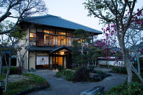 a building with a lot of windows and trees at NIPPONIA HOTEL Ozu Castle Town in Ōzu