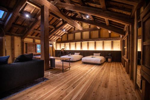 Ōzu的住宿－NIPPONIA HOTEL Ozu Castle Town，大房间设有两张床和一张沙发