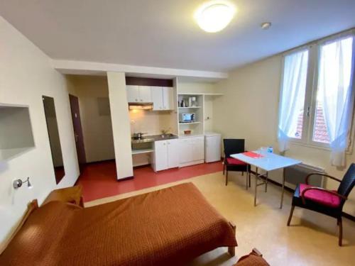 un salon avec un canapé et une table et une cuisine dans l'établissement Studios LOC AG2, à Dax