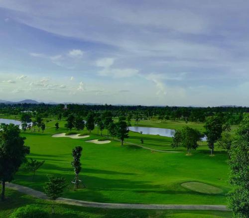 an overhead view of a golf course with a lake at Happy City Golf & Resort in Chiang Rai