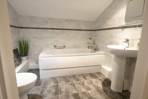 a bathroom with a tub and a toilet and a sink at Hill Top Farm 8 in Bainbridge