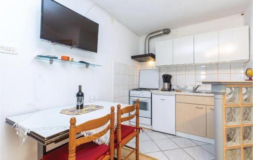 a kitchen with a counter and a table and chairs at Amazing Apartment In Bakar With Kitchen in Bakar
