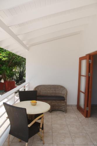 a patio with a table and chairs and a couch at Bantopa Apartments in Willemstad