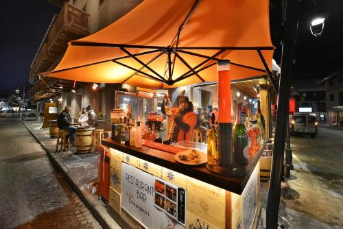 a food cart with an orange umbrella on a street at Hotel Compagnoni in Livigno