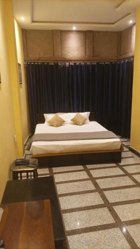 a bedroom with a large bed with black curtains at Jodhpur Palace Guest House in Jodhpur