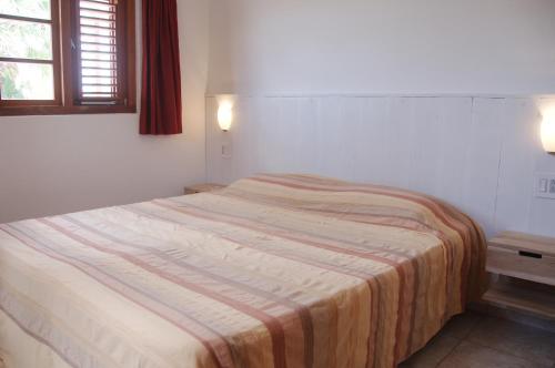 a bedroom with a bed with a striped blanket on it at Bantopa Apartments in Willemstad