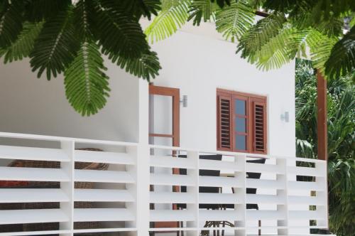 a white house with palm trees in front of it at Bantopa Apartments in Willemstad