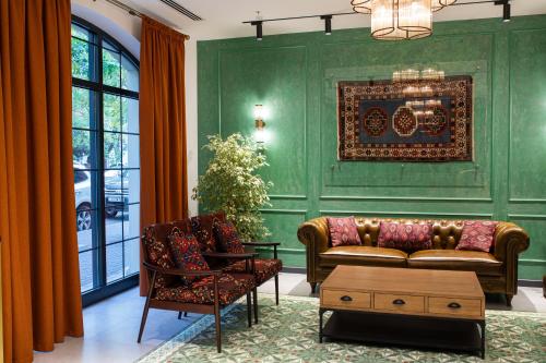 a living room with green walls and a couch and chairs at Molokan Inn Hotel in Baku