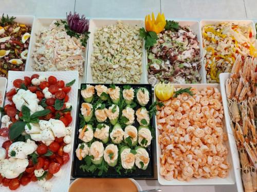 a bunch of different types of food on a table at Hotel Nettuno in Lido di Jesolo