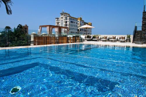 una gran piscina azul con un edificio en el fondo en Bastión Luxury Hotel, en Cartagena de Indias