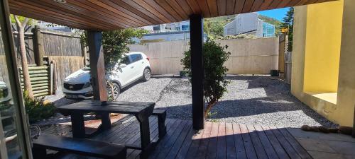 a patio with a table and a car parked in a driveway at Hout Bay Breeze Guest House in Hout Bay