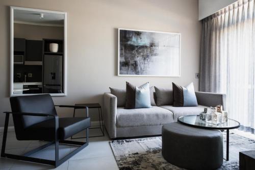 a living room with a couch and a chair at The Capital Trilogy Menlyn Maine in Pretoria