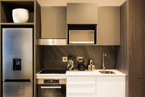 a kitchen with a sink and a microwave at The Capital Trilogy Menlyn Maine in Pretoria