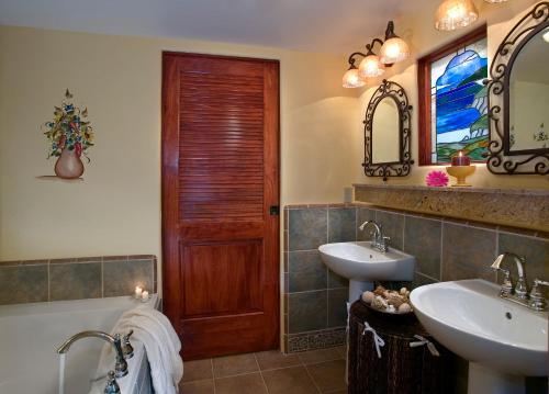 a bathroom with two sinks and a wooden door at Avila La Fonda Hotel in Avila Beach