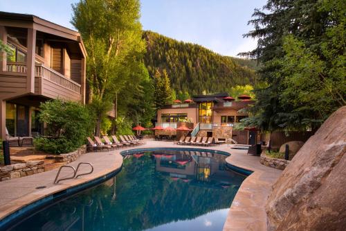 a swimming pool with chairs and a house at The Gant in Aspen