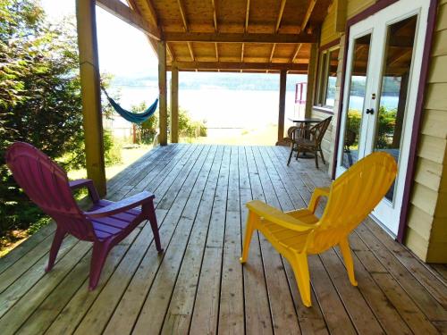 three chairs sitting on a porch of a house at Alert Bay Lodge in Alert Bay
