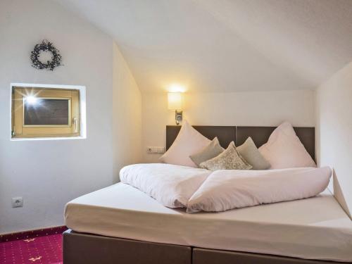 ein Schlafzimmer mit einem großen Bett mit weißer Bettwäsche und Kissen in der Unterkunft Spacious Apartment in Kaltenbach with Garage in Kaltenbach