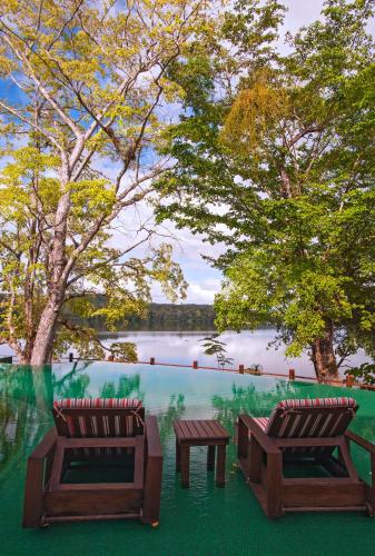two benches and a table in front of a lake at Las Lagunas Boutique Hotel in Flores