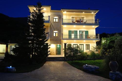 a large white building with a tree in front of it at Evianna Studios in Mousata