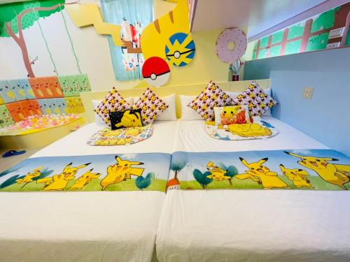 a bedroom with two beds with winnie the pooh pillows at 芹菜芋頭親子民宿 in Taitung City