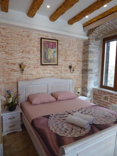 a bedroom with a large bed with pink pillows at Apartaments Charlie Chaplin in Kotor