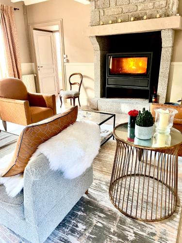 a living room with a couch and a fireplace at La Maison Gervaiserie & Spa in Réville