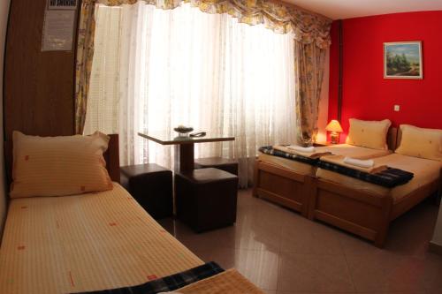 a bedroom with two beds and a red wall at Villa Ohrid Anastasia in Ohrid