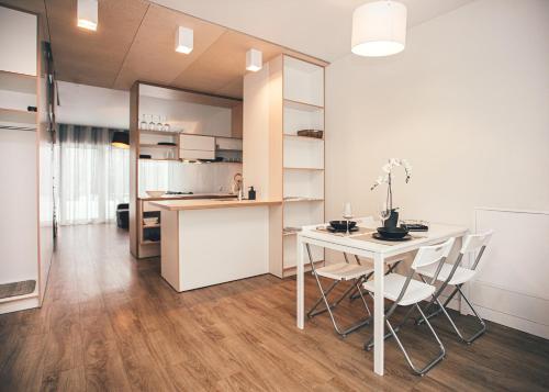 uma cozinha e sala de jantar com mesa e cadeiras em Ring Stop Holiday Apartment em Sigulda